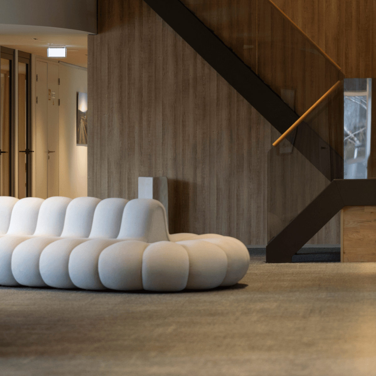 White designer sofa in modern office hall with staircase HVK Stevens