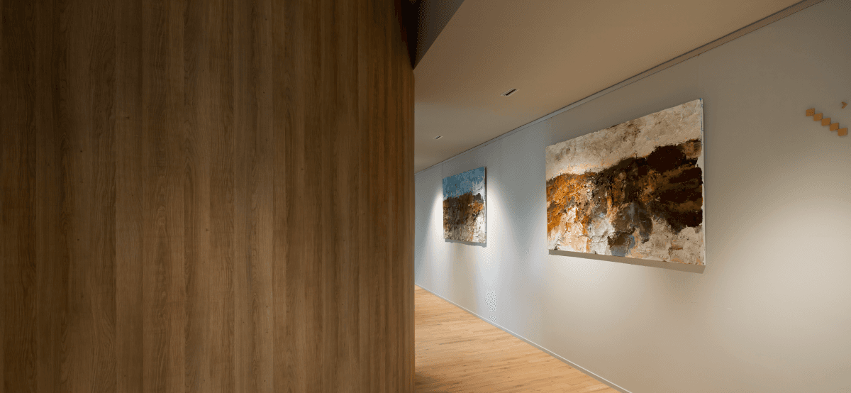 gang met houten vloer en twee kunstschilderijen hvk stevens