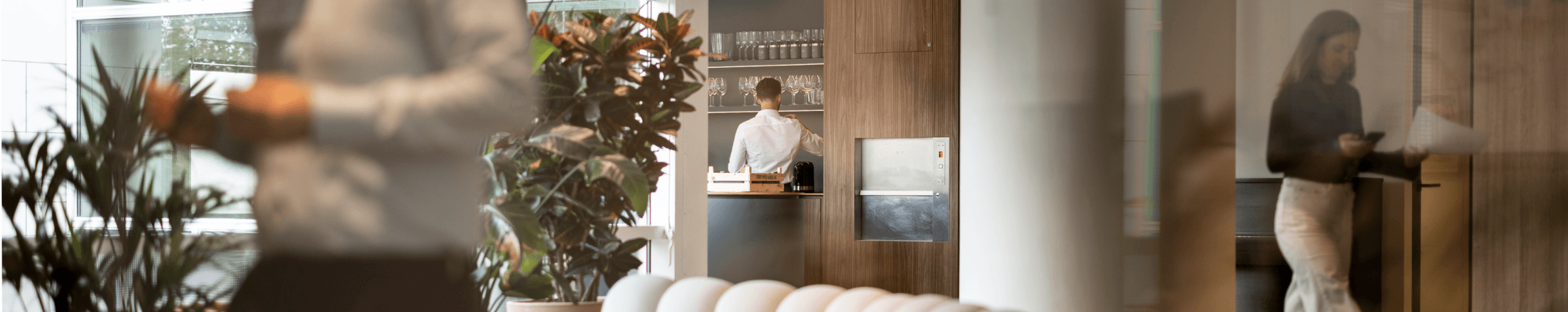 Moderne loungehoek met witte bank en collega’s in achtergrond hvk stevens