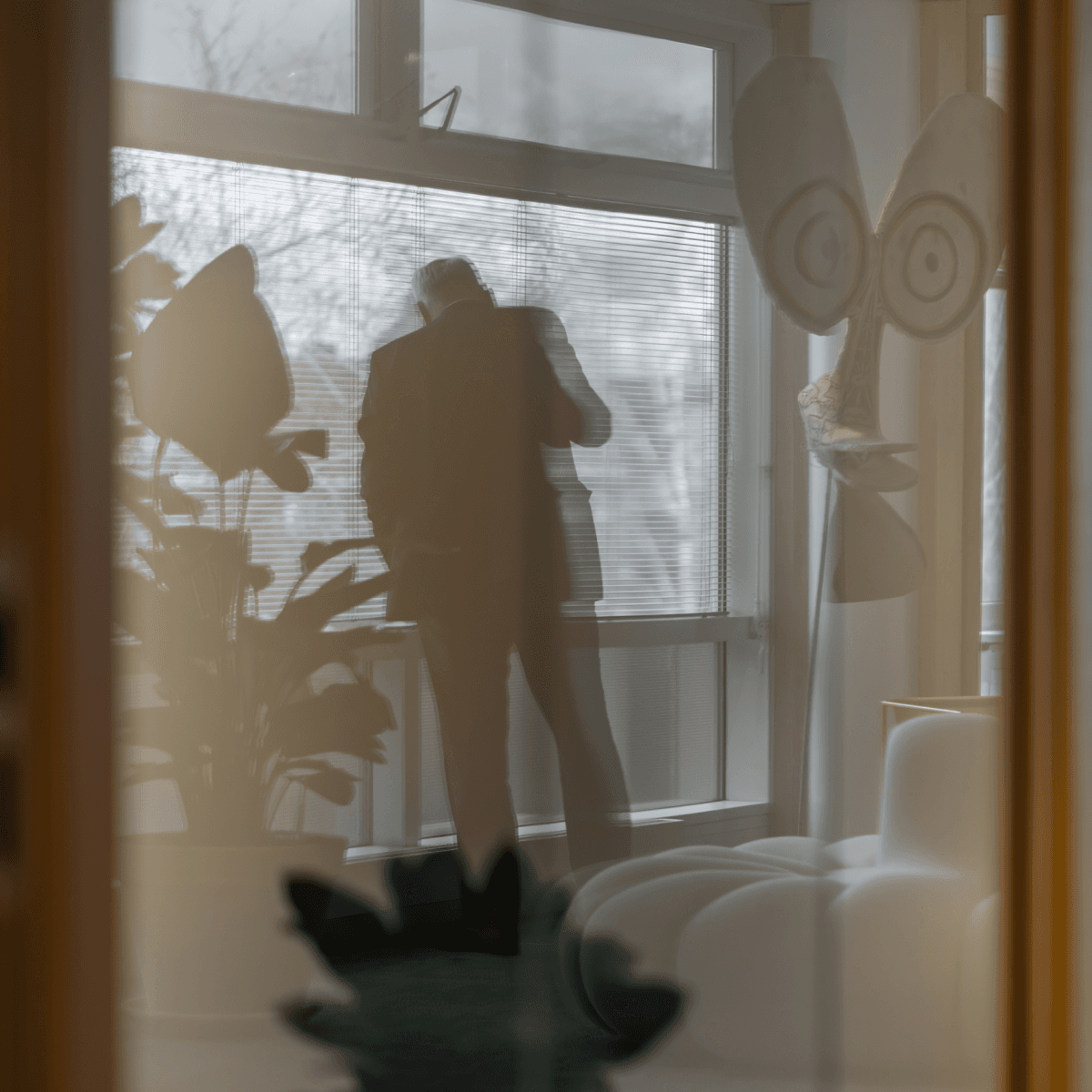 Silhouet van man bij raam gezien door reflectie in gang HVK Stevens