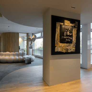 witte designbank met kunstwerk op muur HVK Stevens