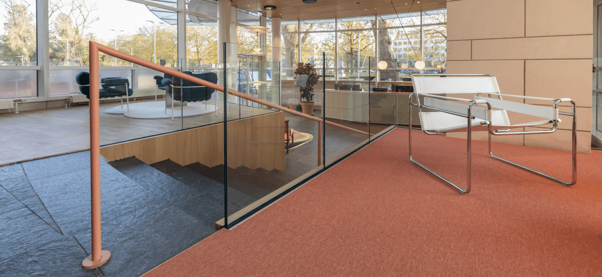 Witte designstoel op oranje vloerkleed in moderne loungehoek HVK Stevens