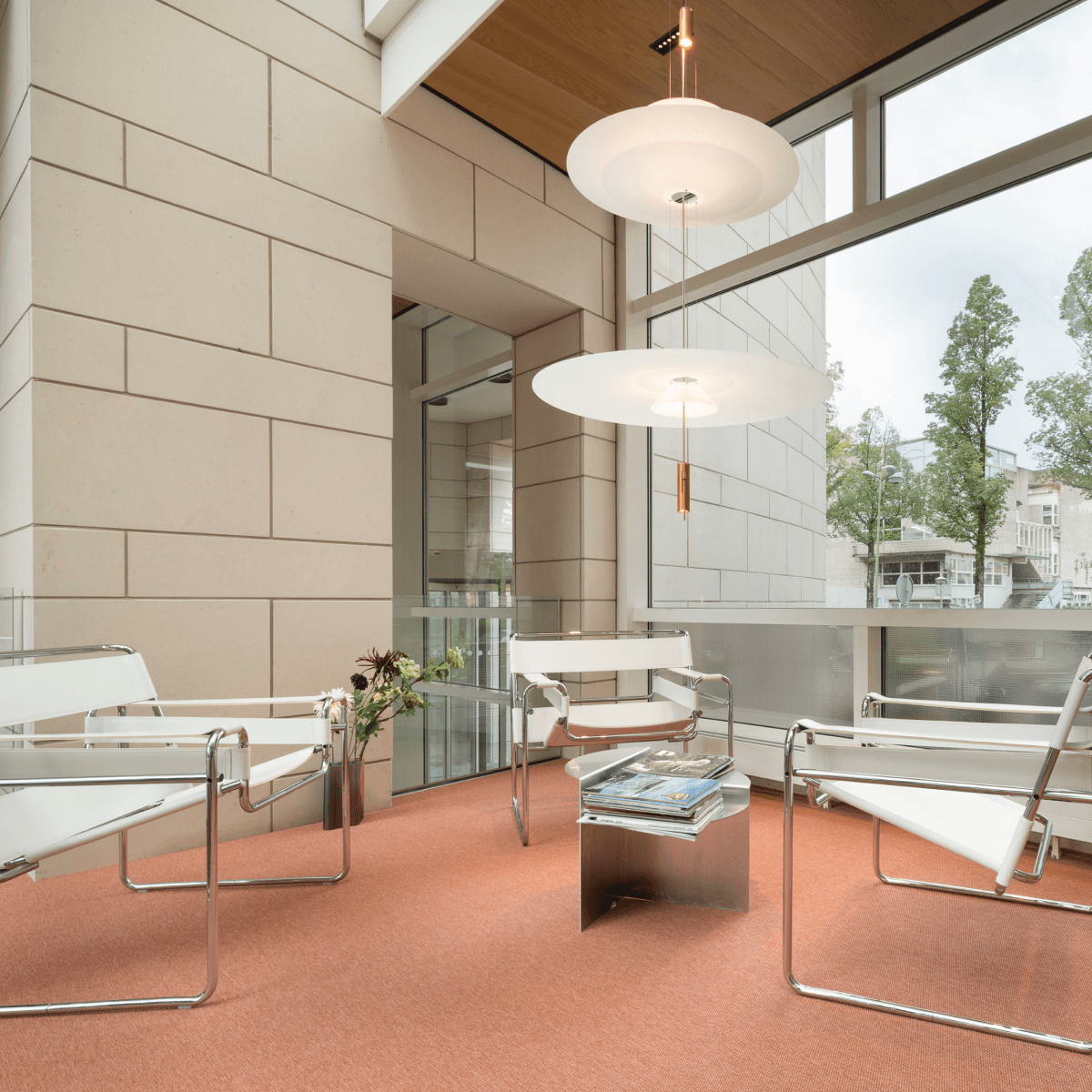 Zithoek met witte stoelen en oranje vloer in kantoorruimte HVK Stevens