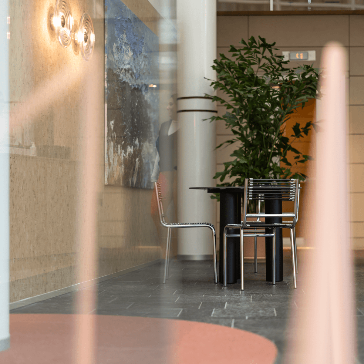 Zithoek met zwarte tafel en stoelen bij schilderij HVK Stevens
