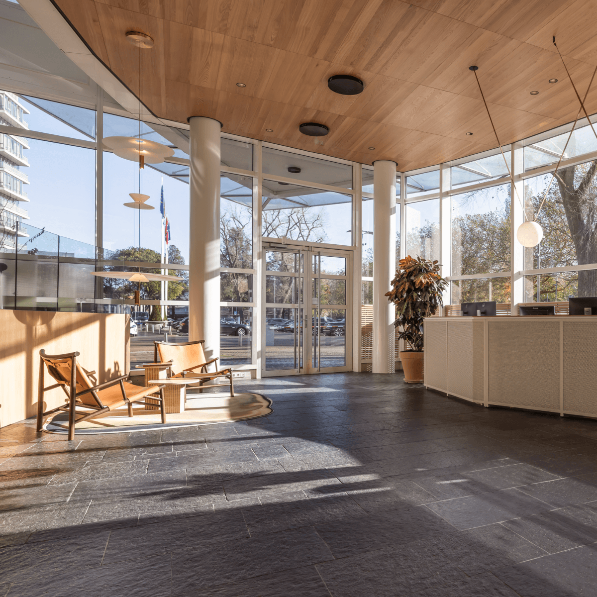 Three HVK Stevens advisors in suits on a modern office terrace with glass railing and city view