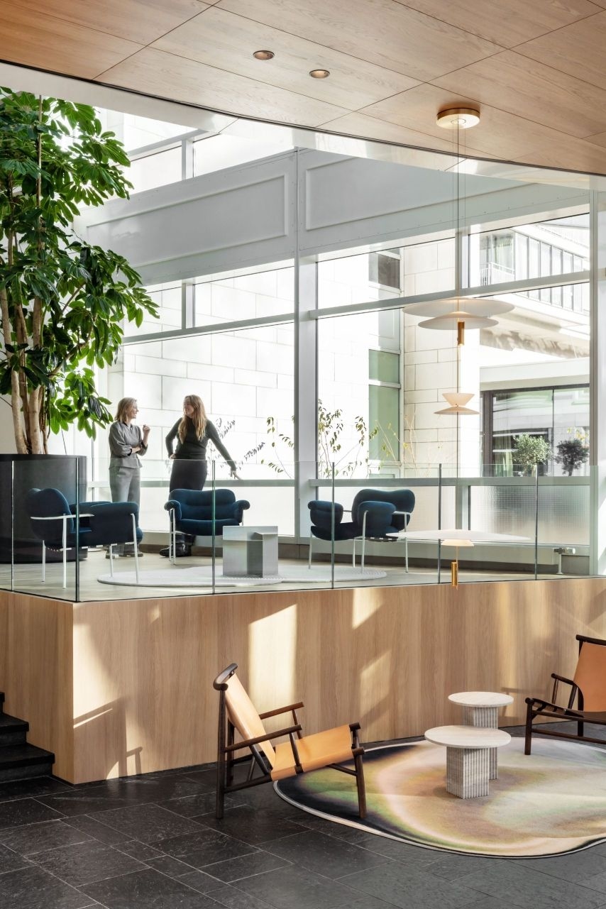 Modern atrium with large plant seating area and two businesspeople in conversation at HVK Stevens