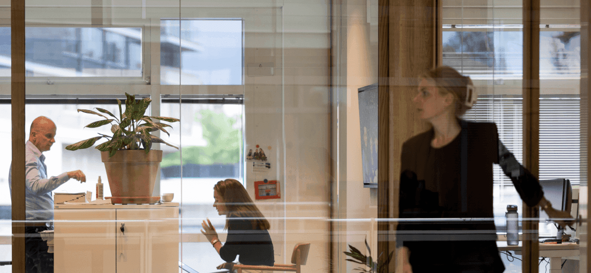 Kantoorinterieur met collega’s in overleg door glaswand