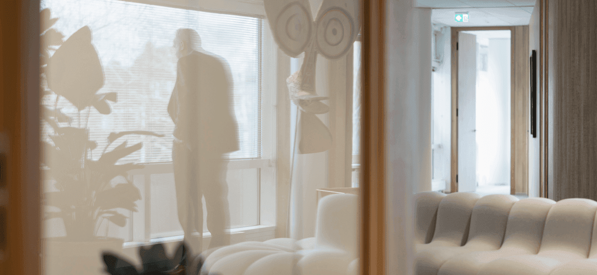 Man bij raam met reflectie in kantoorruimte
