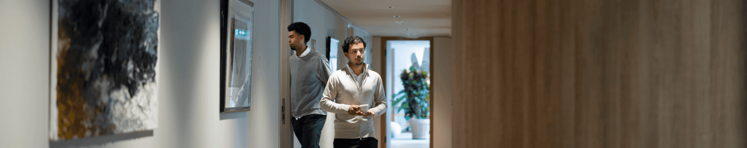 Medewerkers in gang met abstracte kunst aan de muur