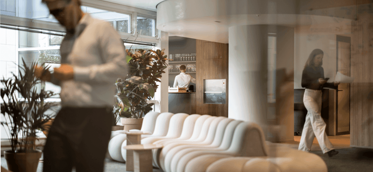 Modern lounge area with white sofa and colleagues in background hvk stevens