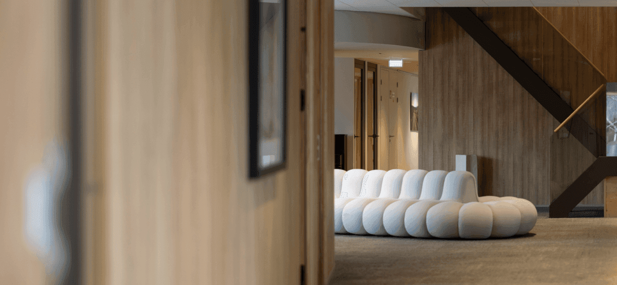 Witte designbank in moderne kantoorhal met trap